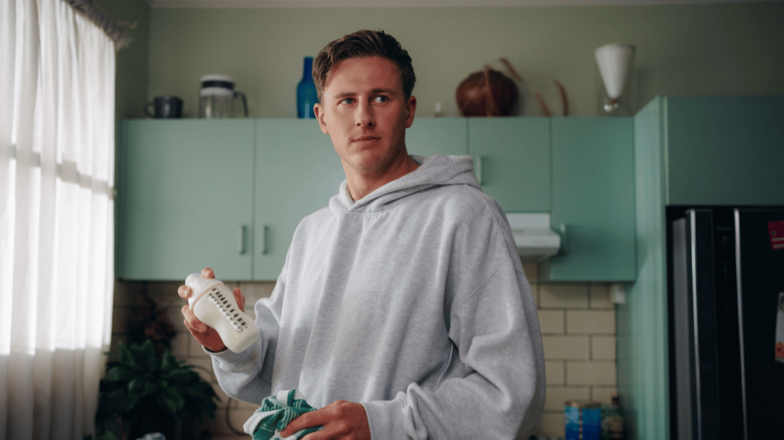 Adam, a What Kind of Man Do You Want to Be participant, prepares a baby's bottle in his kitchen.