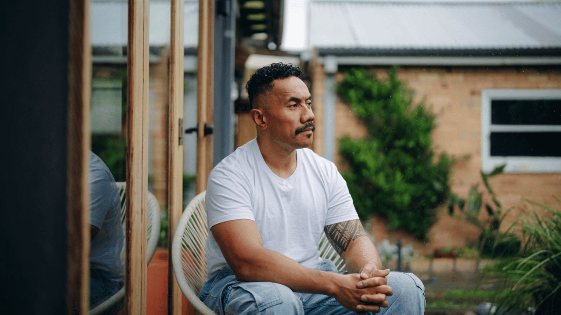 Fui, a What Kind of Man Do You Want to Be participant, sits in his back yard.