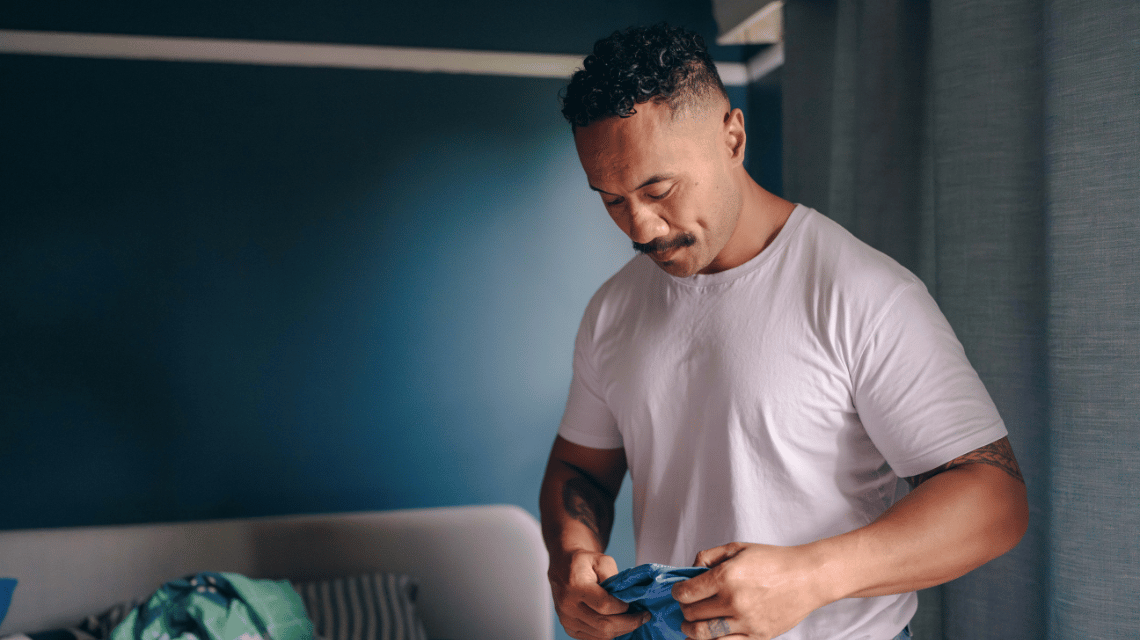 Fui, a What Kind of Man Do You Want to Be participant, folds laundry