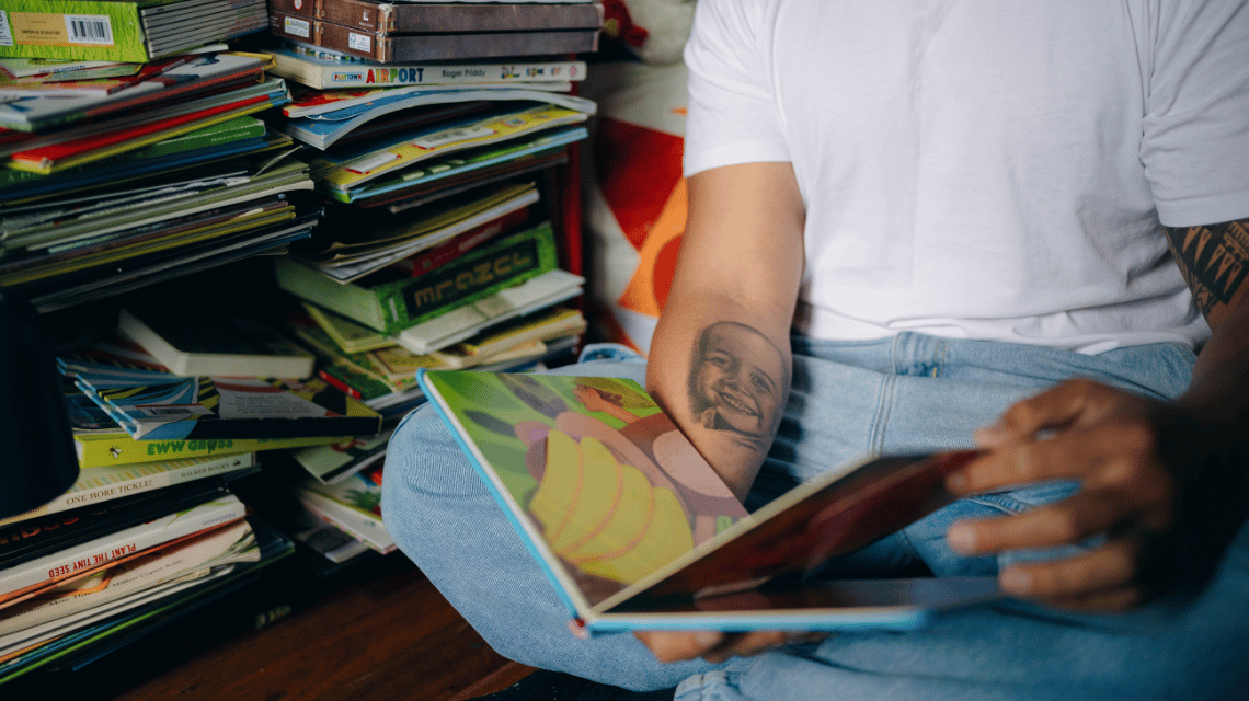 Fui, a What Kind of Man Do You Want to Be participant, looks at his children's story books.