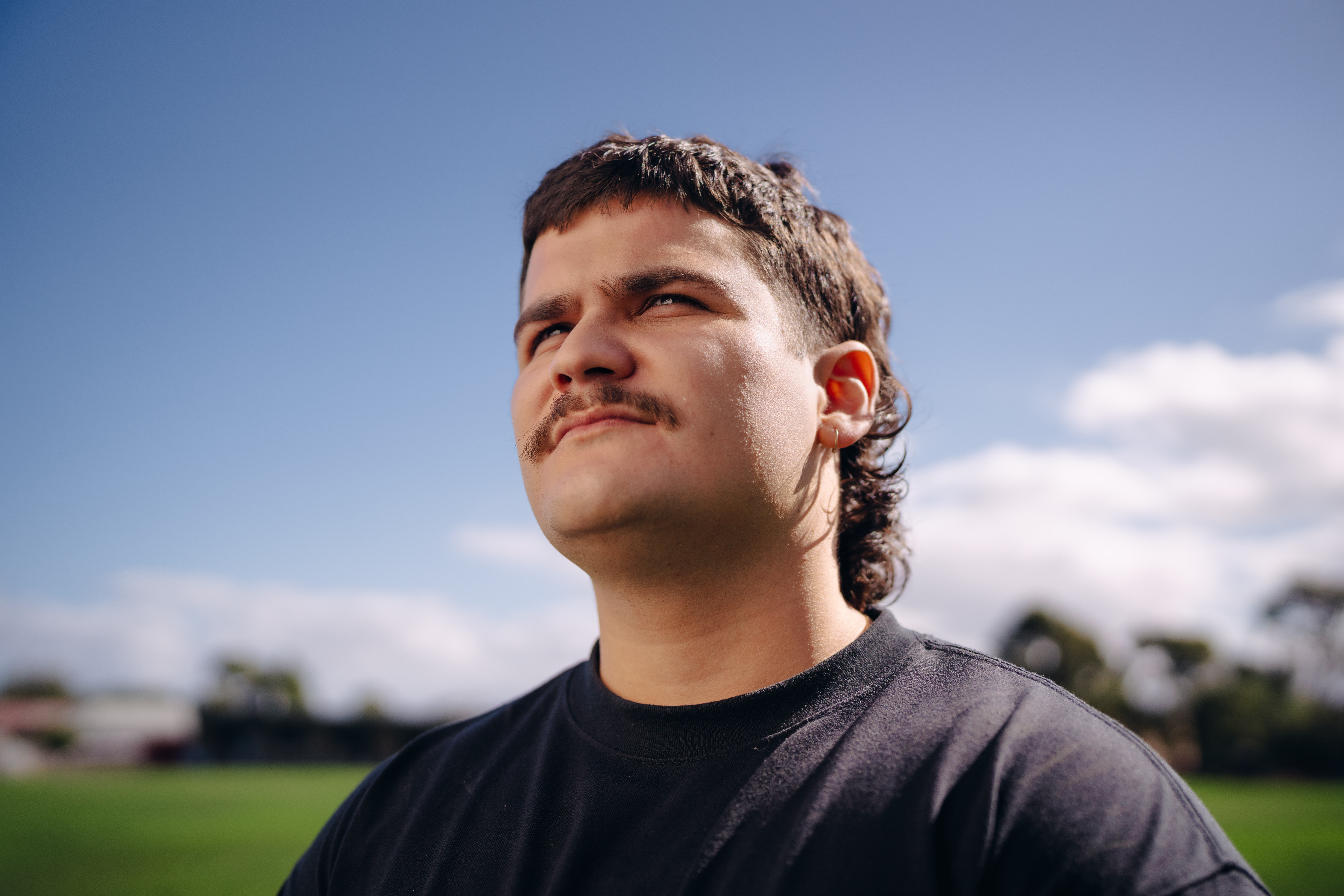 Young man standing on football field looking towards the sun for the What Kind of Man Do You Want to Be? campaign.