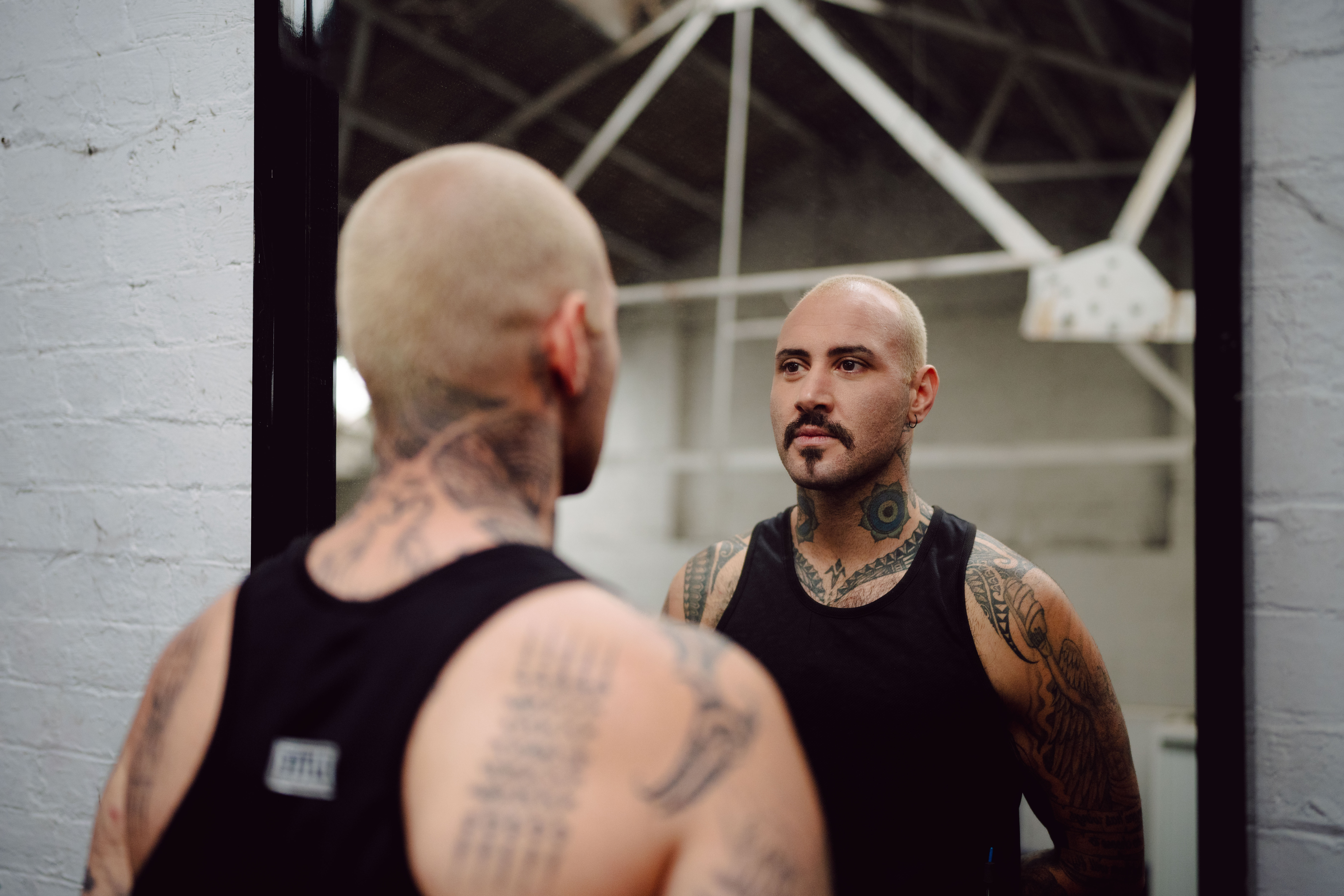 A man looks at his reflection in the mirror at a boxing studio for the What Kind of Man Do You Want to Be? campaign.
