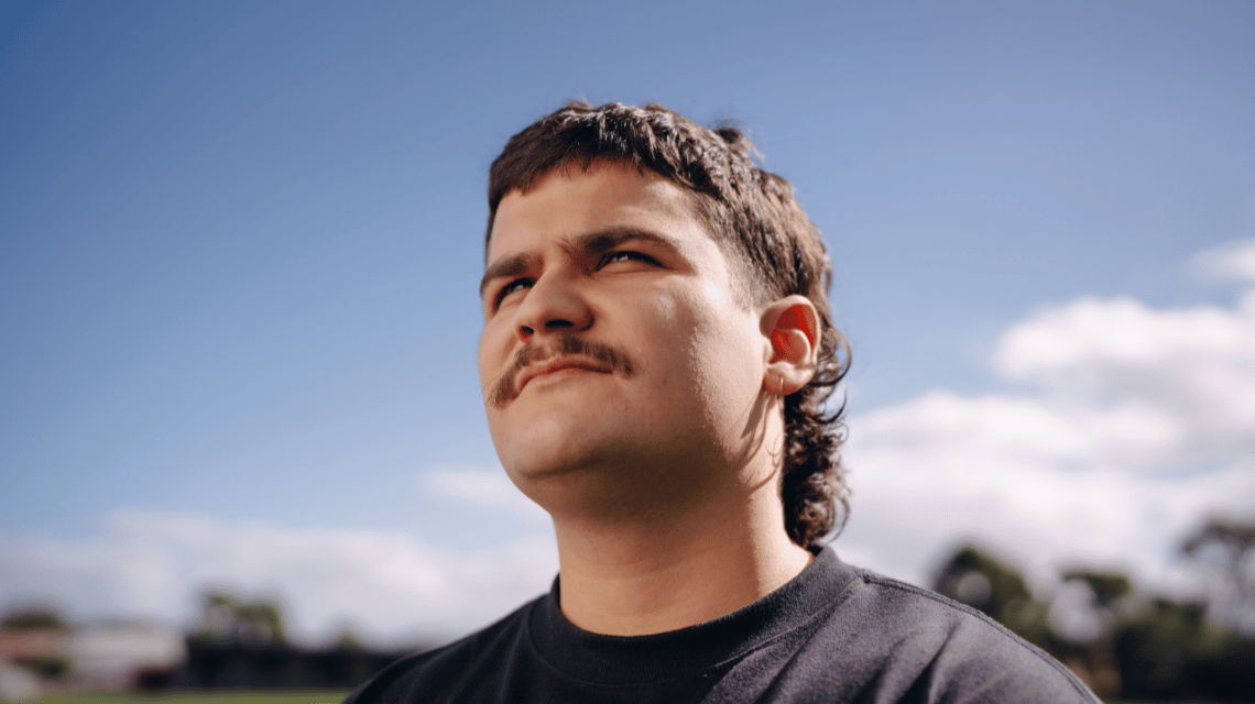 Young man standing on football field looking towards the sun for the What Kind of Man Do You Want to Be? campaign.