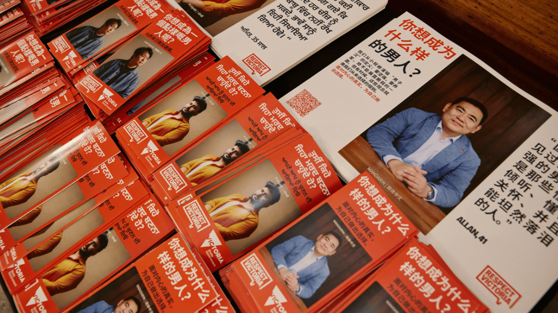 Table display of What Kind of Man Do You Want to Be leaflets and posters written in Punjabi and Chinese (Traditional and Simplified).