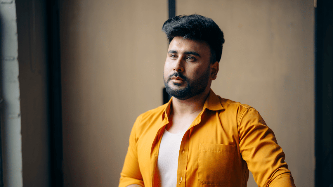 Portrait of a man in a vibrant yellow shirt.