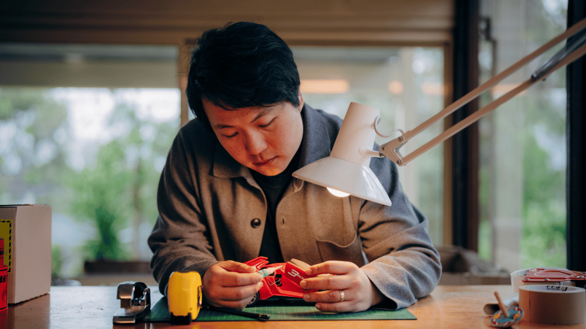 A man carefully fixing a child's broken toy.