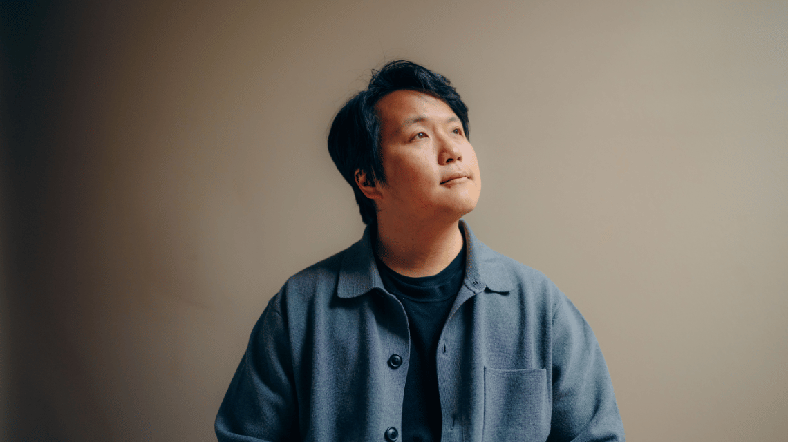 Portrait of a man in a blue shirt, looking away in thought.