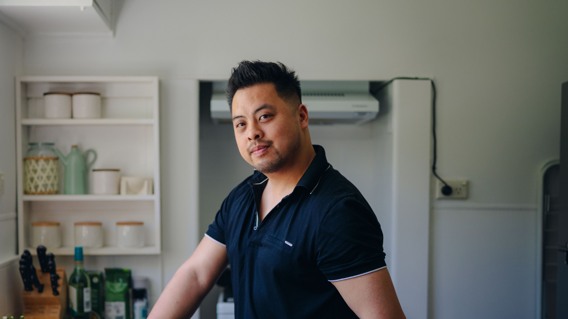 Portrait of a man standing in a home kitchen